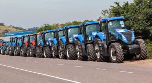 Trattori agricoli di colore blu in fila per strada